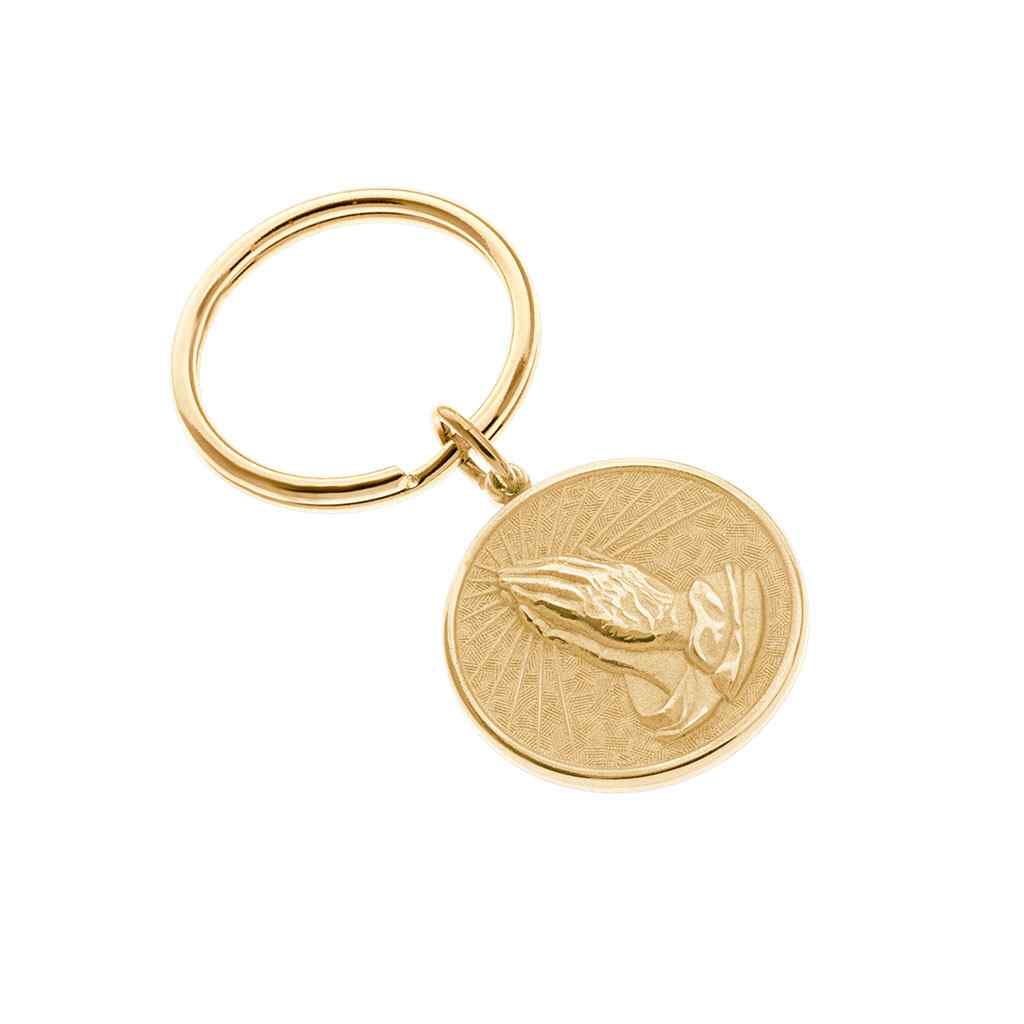 A round praying hands key ring with serenity prayer displayed on a neutral white background.